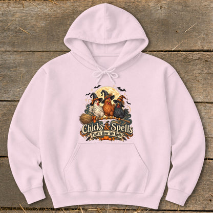 Pink hoodie with "Chicks & Spells" and three witch-hatted chickens on a broomstick.