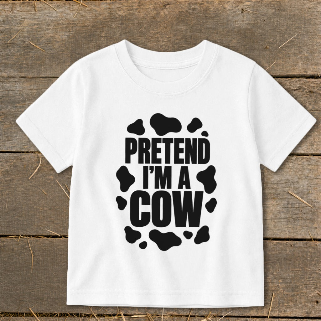 White t-shirt with black text "PRETEND I'M A COW" and cow spots.