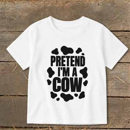 White t-shirt with black text "PRETEND I'M A COW" and cow spots.