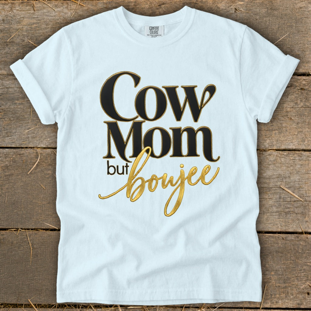 White t-shirt with "Cow Mom but Boujee" text in black and gold.