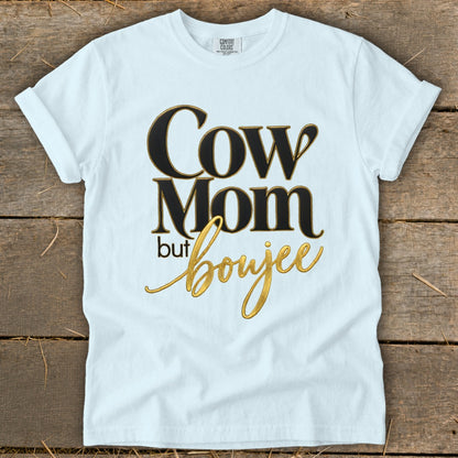 White t-shirt with "Cow Mom but Boujee" text in black and gold.