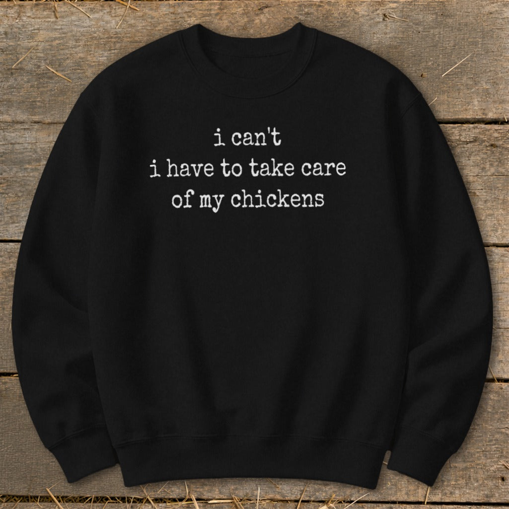 Black sweatshirt with white text reading "i can't i have to take care of my chickens."