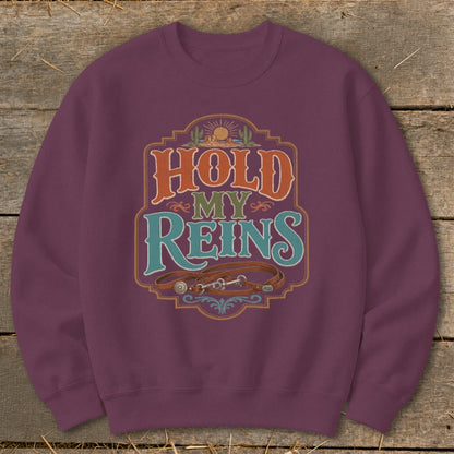 Maroon sweatshirt with "Hold My Reins" text and horse tack graphic.