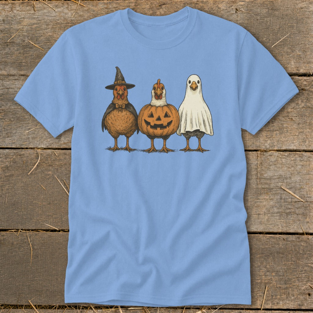 Three chickens dressed for Halloween: witch, pumpkin, and ghost costumes.