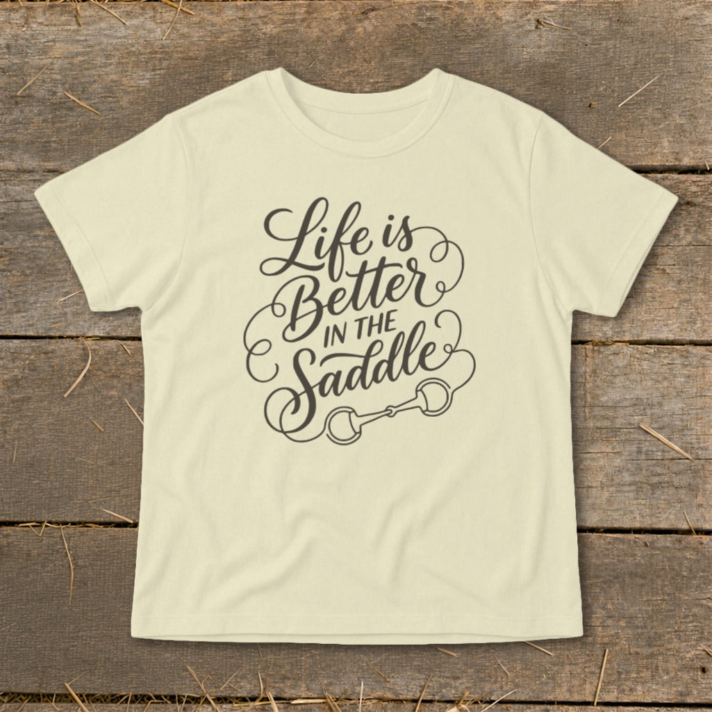 Cream t-shirt with "Life is Better In The Saddle" text and horse bit graphic.