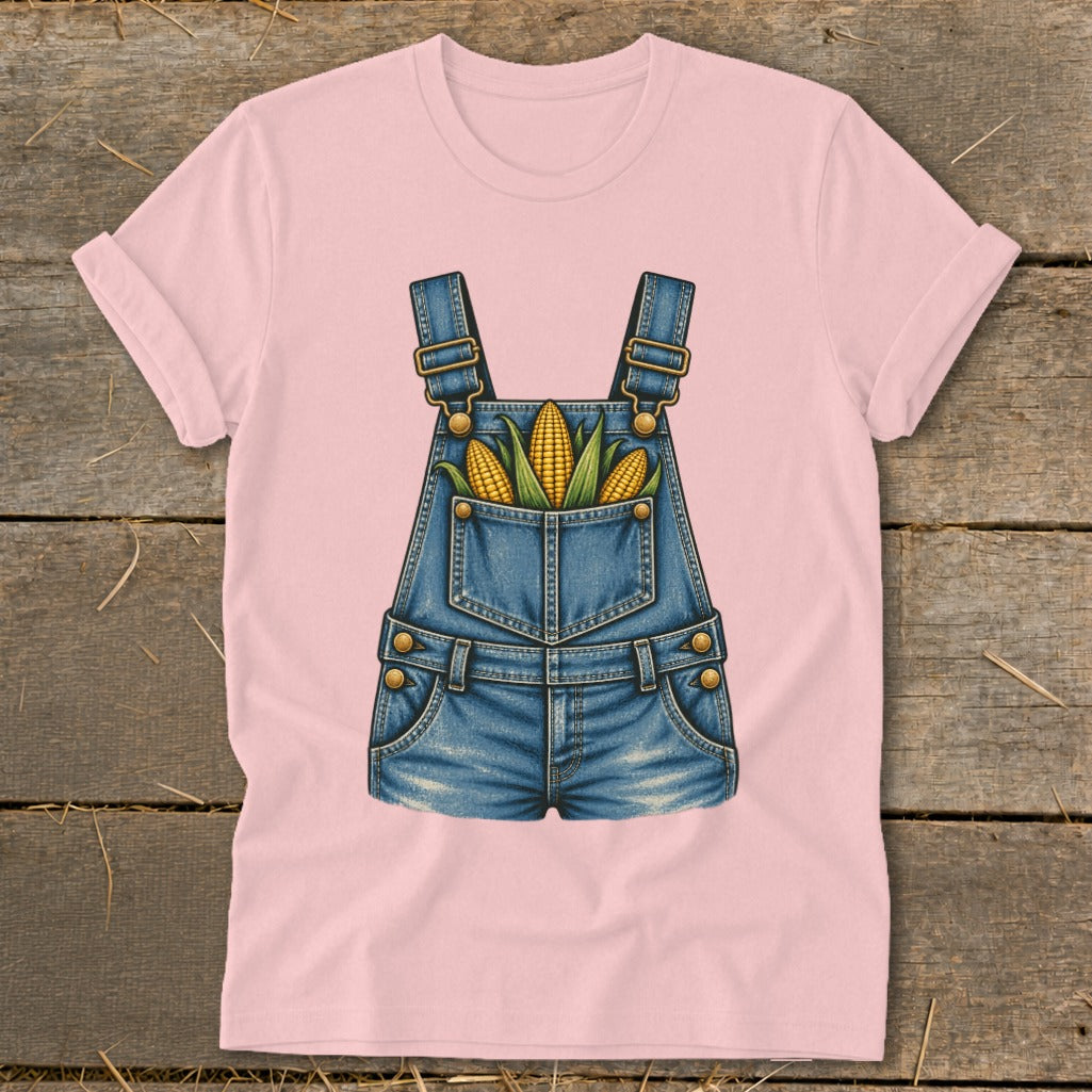 Pink t-shirt with a graphic of denim overalls filled with corn cobs.