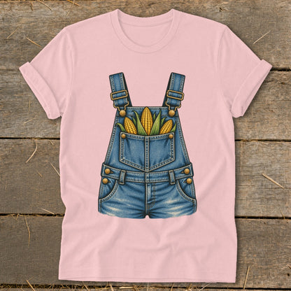 Pink t-shirt with a graphic of denim overalls filled with corn cobs.