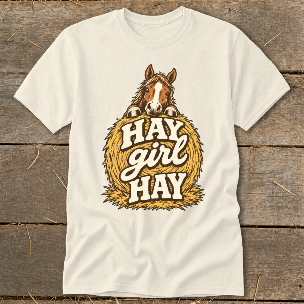 Cream t-shirt with horse peeking over hay bale saying "Hay girl hay".