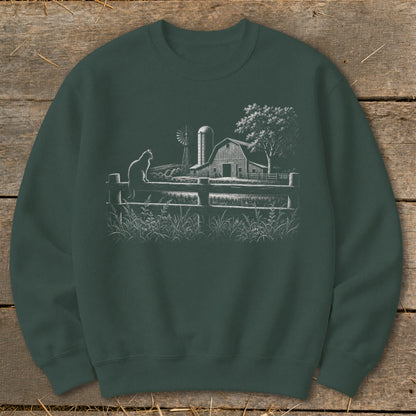 Green sweatshirt with a white line drawing of a cat on a fence, barn, windmill, and tree.