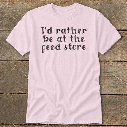 Light pink t-shirt with black text that reads "I'd rather be at the feed store."