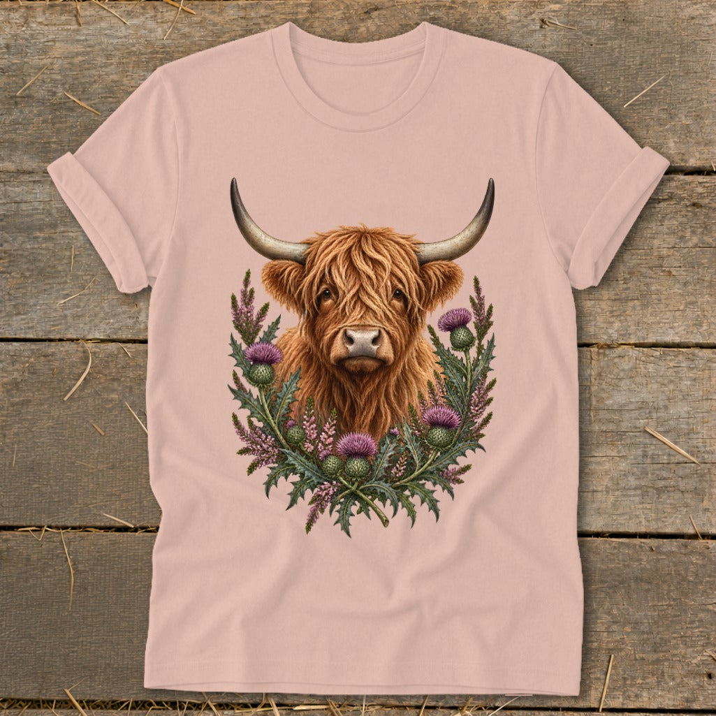 Highland cow with thistle wreath graphic on a pink t-shirt.