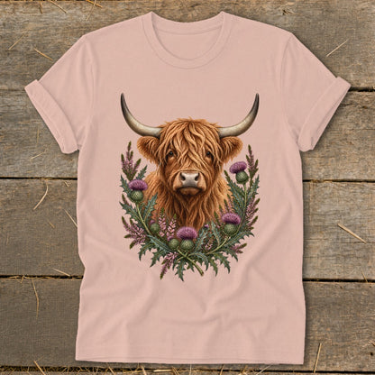 Highland cow with thistle wreath graphic on a pink t-shirt.