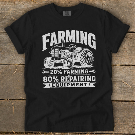 A black short-sleeved t-shirt with a distressed white tractor graphic and text reading 20 percent farming 80 percent repairing equipment.