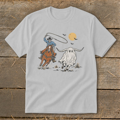 Skeleton cowboy on horse chasing a ghost with bull horns under a pale moon.