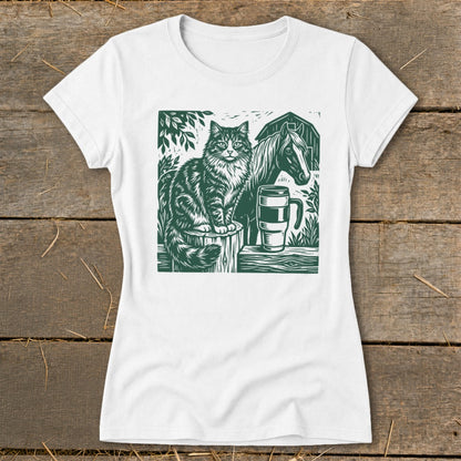 White t-shirt with a green linocut print of a cat, horse, and mug.