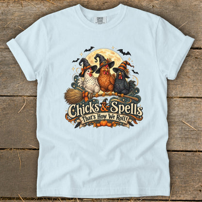 Three chickens in witch hats ride a broomstick with text "Chicks & Spells That's How We Roll!"