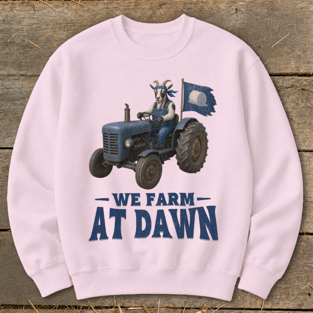 Goat in overalls drives tractor with flag, "We Farm At Dawn" text.