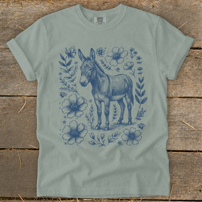 Donkey with blue floral wreath on a light green t-shirt.