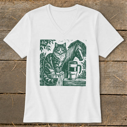 Green linocut art of a cat, horse, barn, and coffee mug on a white t-shirt.