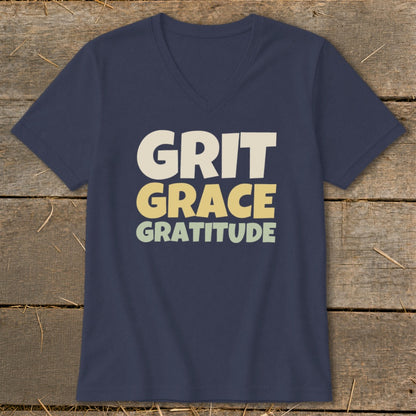 A dark blue V-neck t-shirt with the words Grit, Grace, and Gratitude printed on the front.