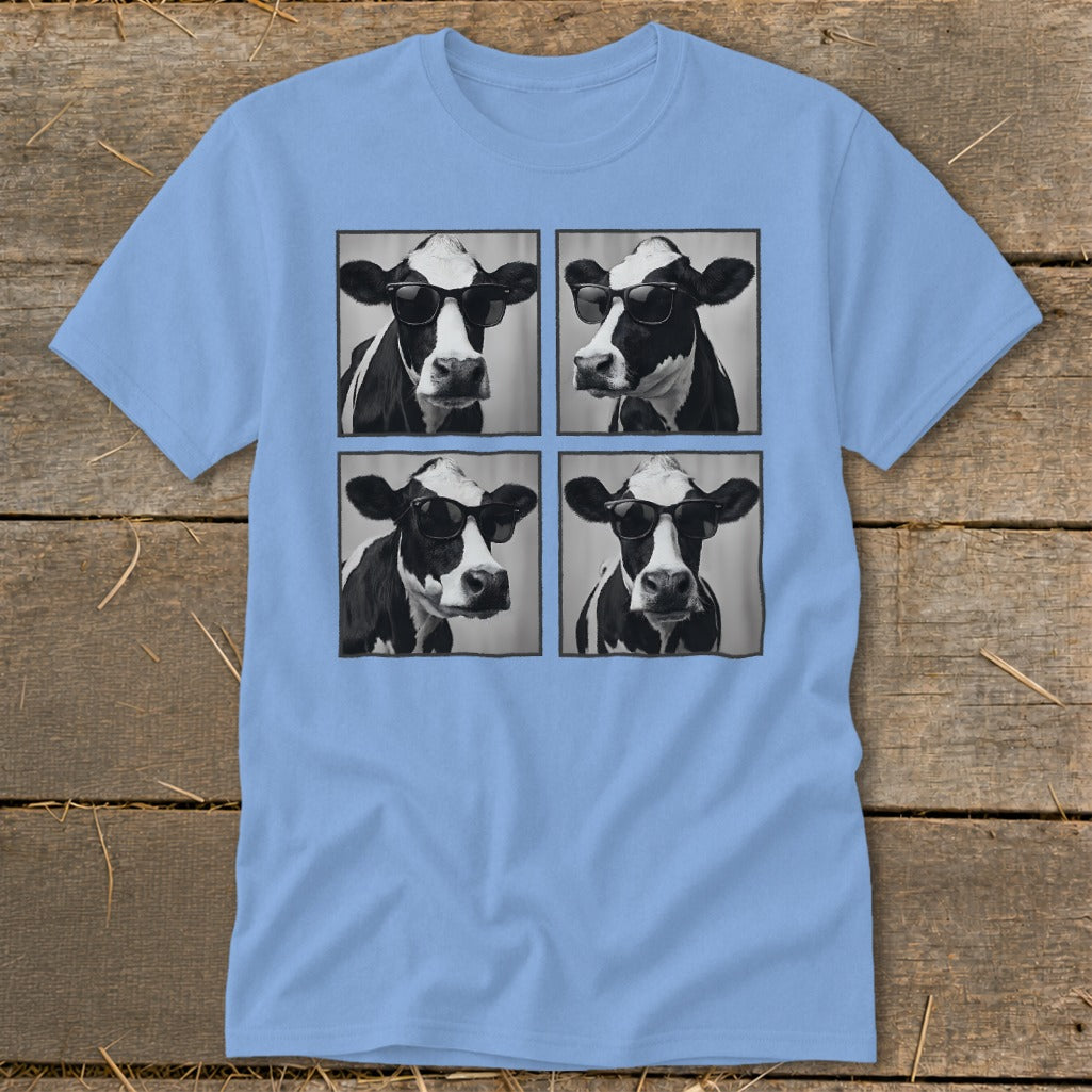 Four black and white cow portraits wearing sunglasses, arranged in a grid on a light blue t-shirt.