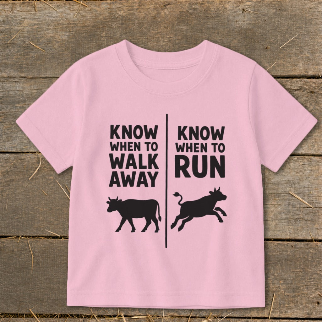 Pink t-shirt with text "Know When To Walk Away" and "Know When To Run" above cows.