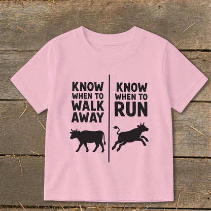 Pink t-shirt with text "Know When To Walk Away" and "Know When To Run" above cows.