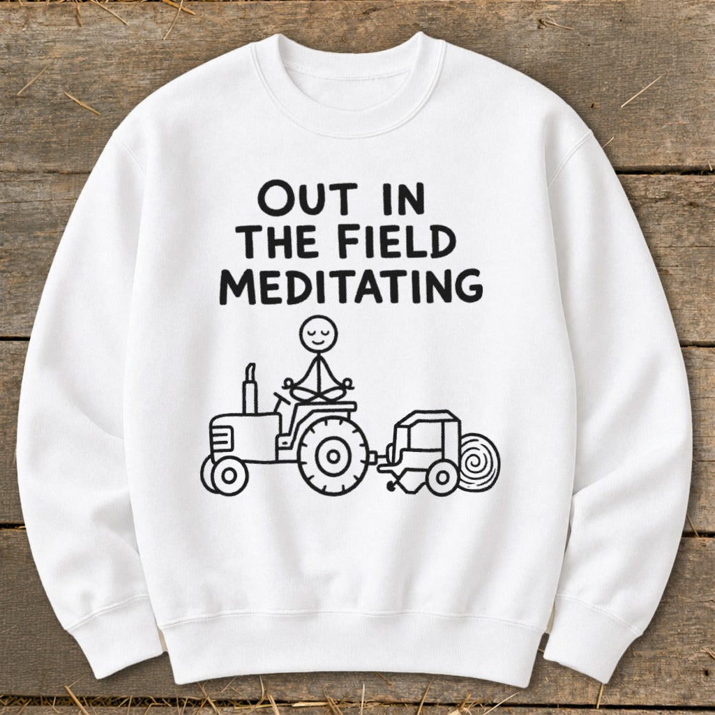 White sweatshirt with black text and stick figure drawing of a person meditating on a tractor.