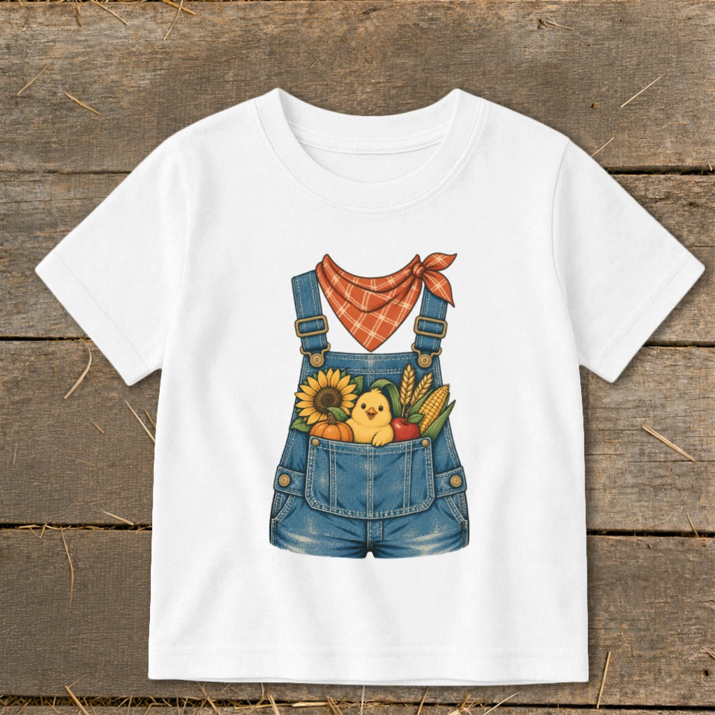 White t-shirt with denim overalls graphic featuring a chick, sunflower, pumpkin, apple, and corn.