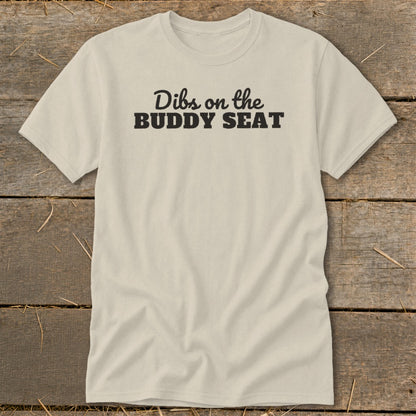 Light tan t-shirt with black text reading "Dibs on the BUDDY SEAT".