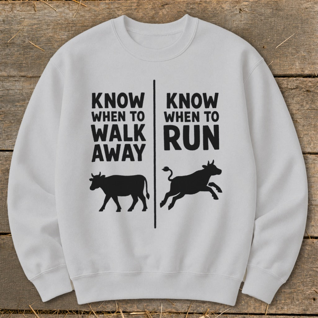 White crewneck sweatshirt with black text and cow silhouettes: "Know When to Walk Away" and "Know When to Run".