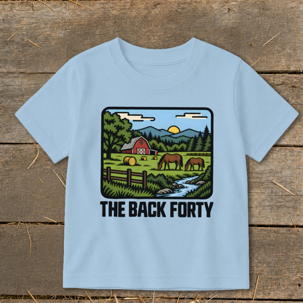 A light blue children's t-shirt printed with a country farm graphic and the text THE BACK FORTY.
