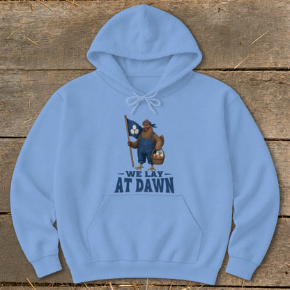 Light blue hoodie with a graphic of a chicken holding a flag and basket, reading "We Lay At Dawn".