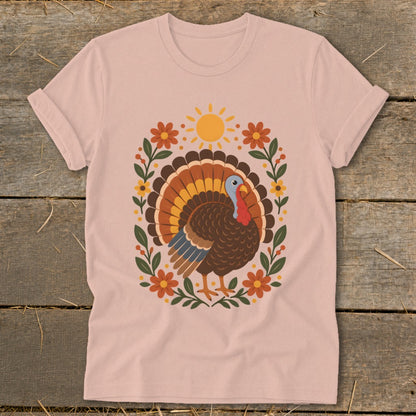 Pink t-shirt with a festive turkey, sun, and floral graphic.