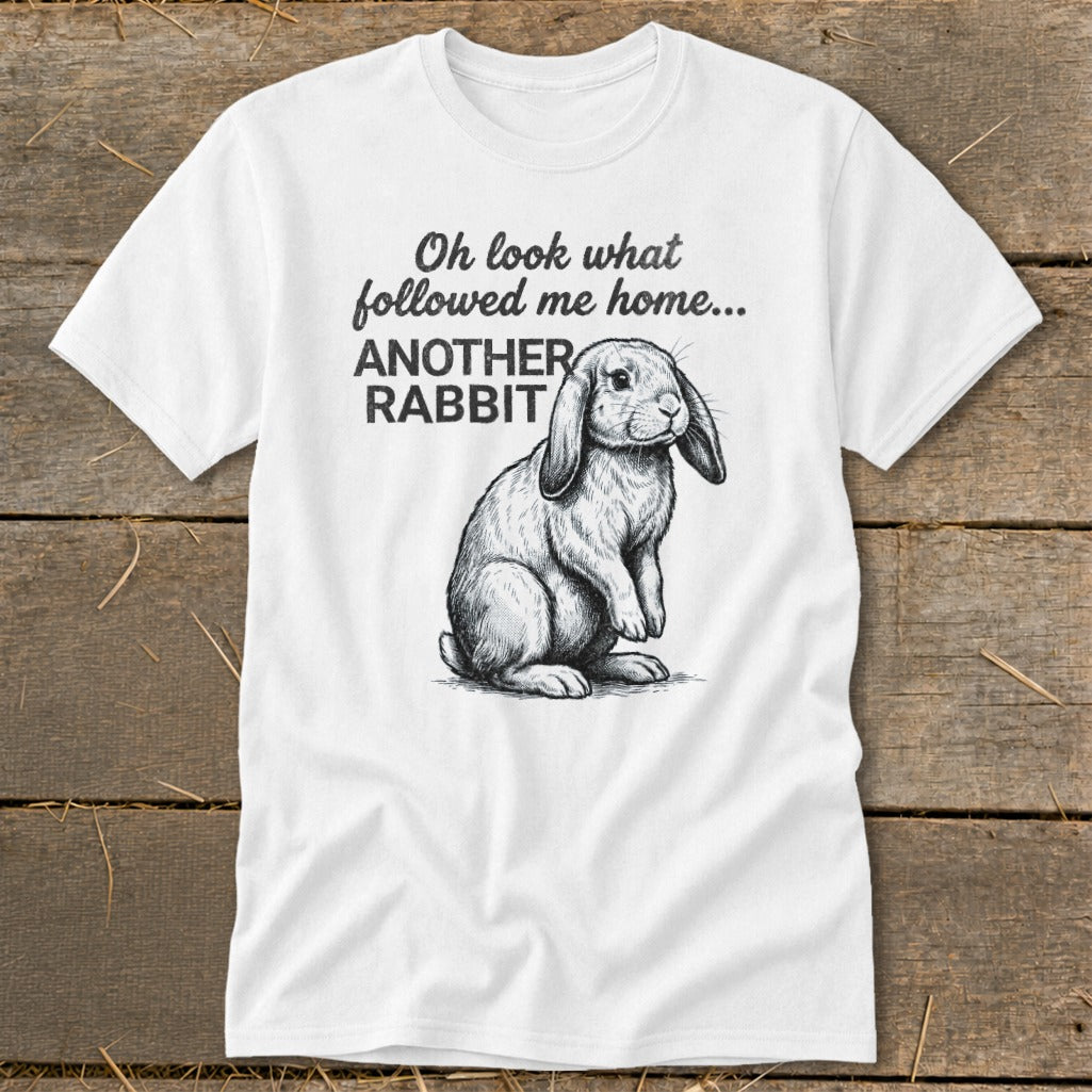 White t-shirt with a sketch of a lop-eared rabbit and text that reads "Oh look what followed me home... ANOTHER RABBIT".