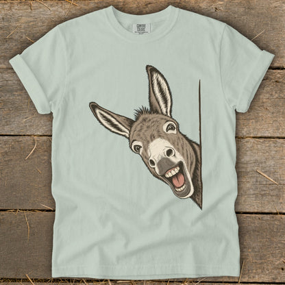 Light blue t-shirt with a smiling donkey peeking from the side.