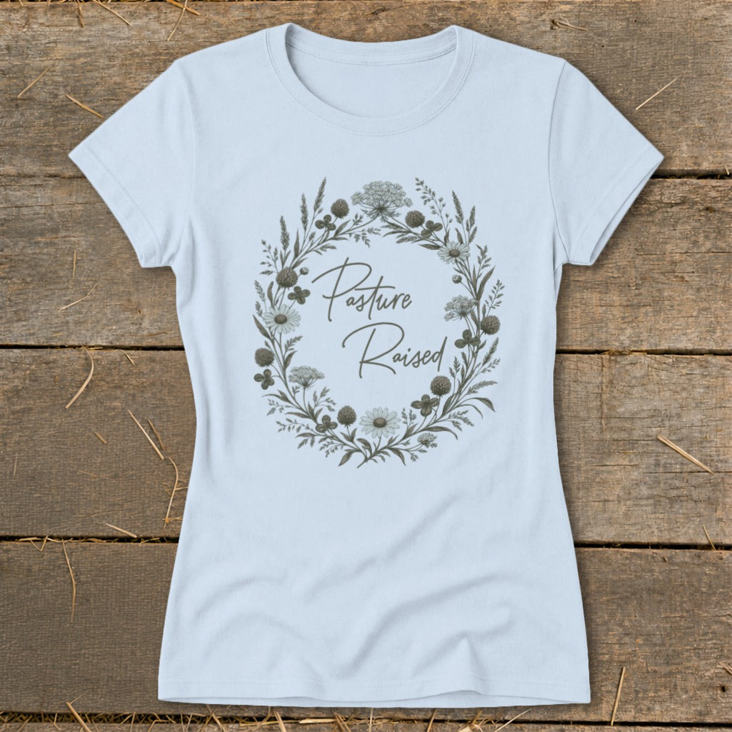 Light blue t-shirt with a floral wreath graphic that reads "Pasture Raised".