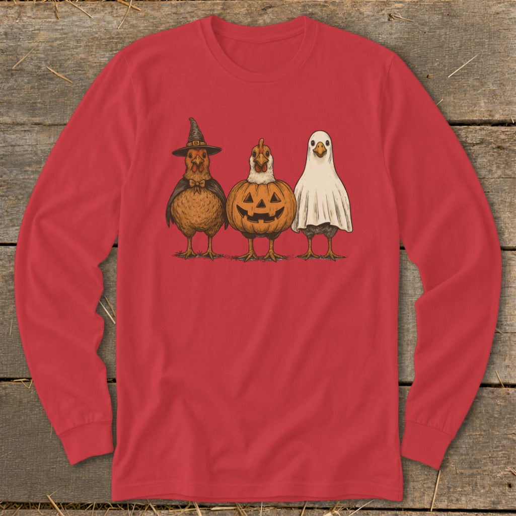 Three chickens dressed for Halloween: one as a witch, one as a pumpkin, one as a ghost.