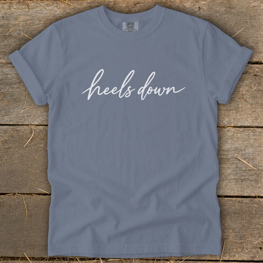 Slate blue t-shirt with white script text "heels down".