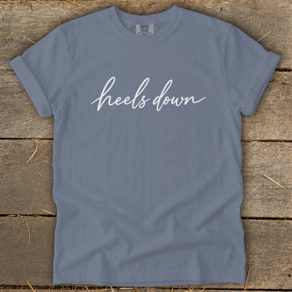 Slate blue t-shirt with white script text "heels down".