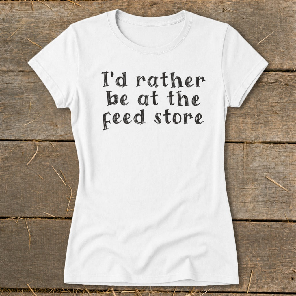 White t-shirt with black text reading "I'd rather be at the feed store".