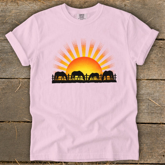 Pink t-shirt with four horses grazing at sunset graphic and Comfort Colors logo.