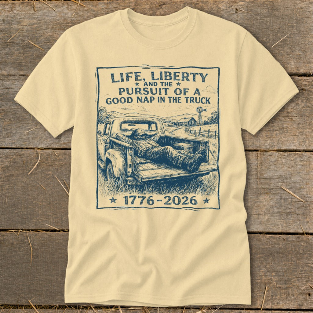 T-shirt with graphic: man napping in truck bed, text "Life, Liberty and the Pursuit of a Good Nap in the Truck 1776-2026".