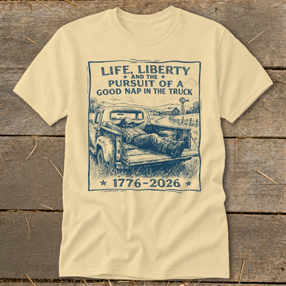 T-shirt with graphic: man napping in truck bed, text "Life, Liberty and the Pursuit of a Good Nap in the Truck 1776-2026".