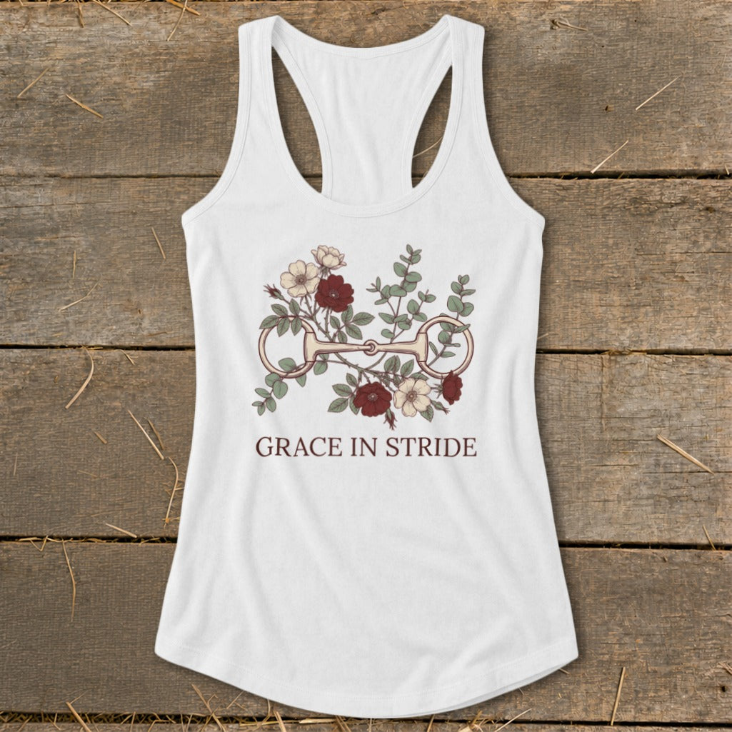 White tank top with a horse bit and floral graphic, reads "GRACE IN STRIDE".