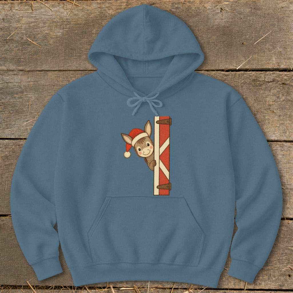 Donkey in Santa hat peeking over red and white barn door on blue hoodie.