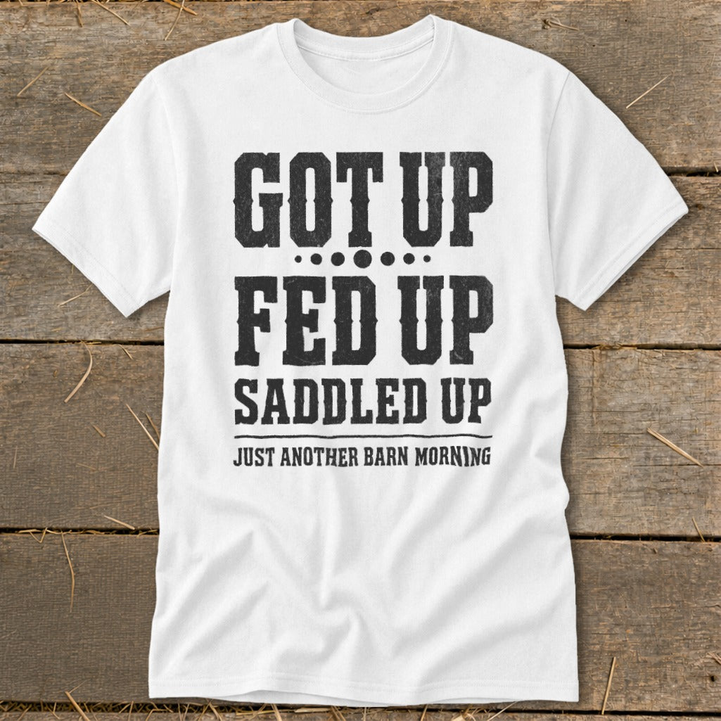 White t-shirt with black distressed text: "GOT UP FED UP SADDLED UP JUST ANOTHER BARN MORNING".