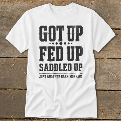 White t-shirt with black distressed text: "GOT UP FED UP SADDLED UP JUST ANOTHER BARN MORNING".