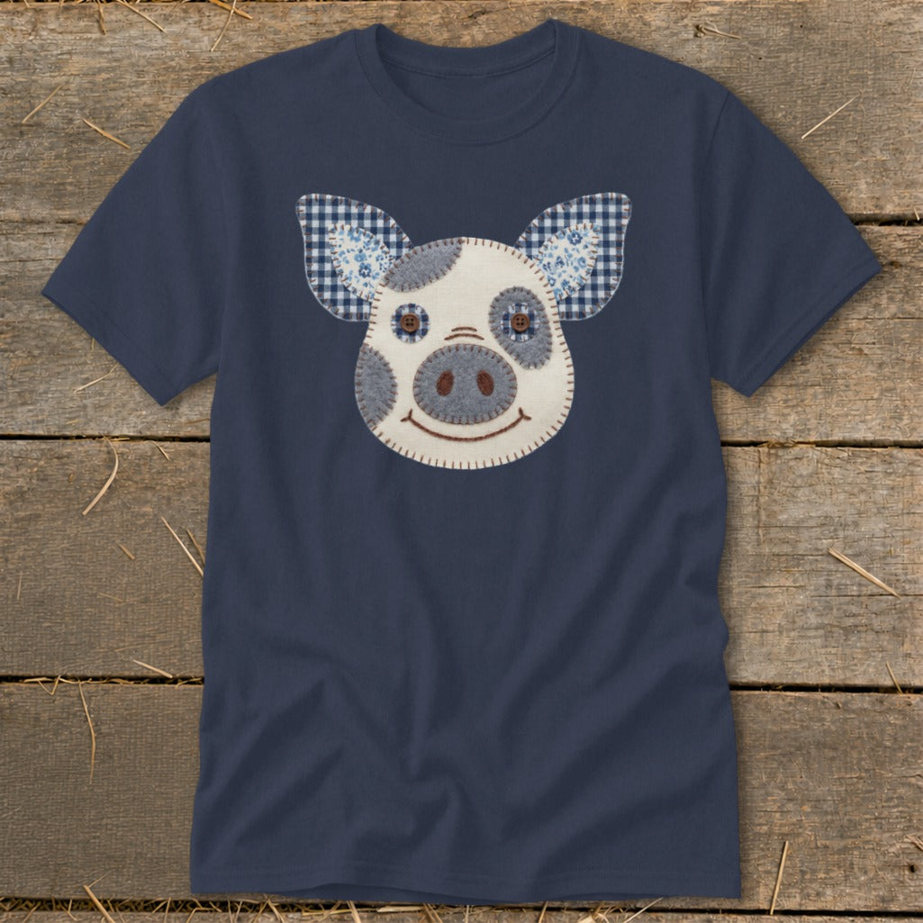 Navy t-shirt with a stitched applique pig face featuring plaid and floral ears.