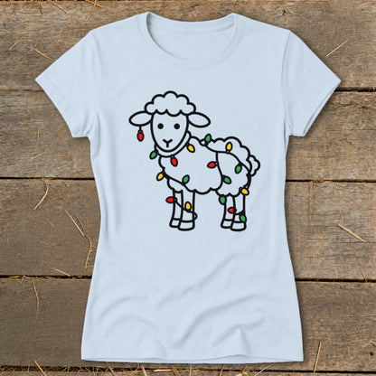 A light blue t-shirt printed with a cartoon sheep wrapped in colorful Christmas lights.